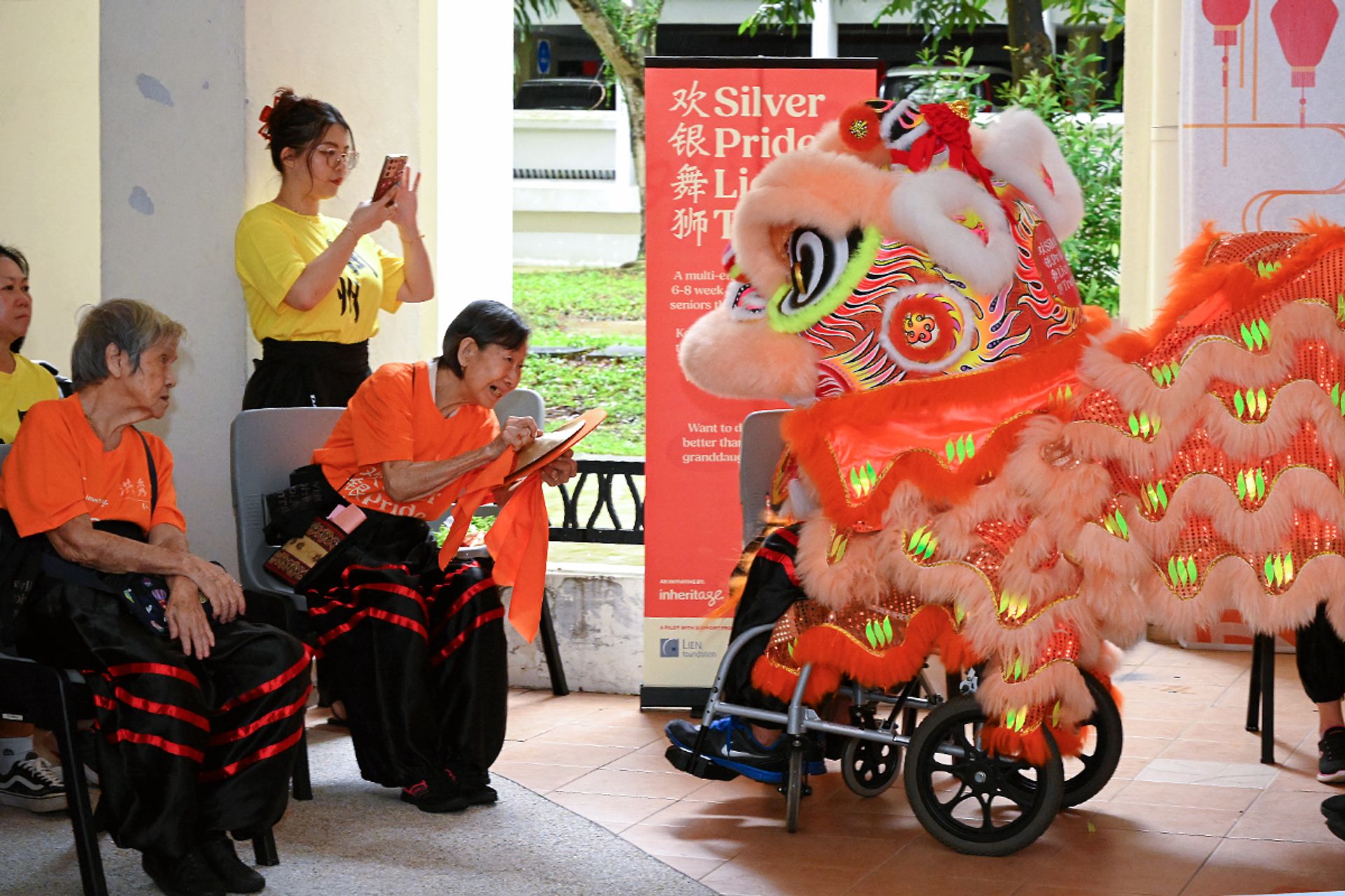 Madam Ng Choon Lan, 86, playing the cymbals as Mr Tan Sung Ming, 68, performs as the lion head during the debut performance of the Silver Pride Lion Troupe on Jan 20, 2024.