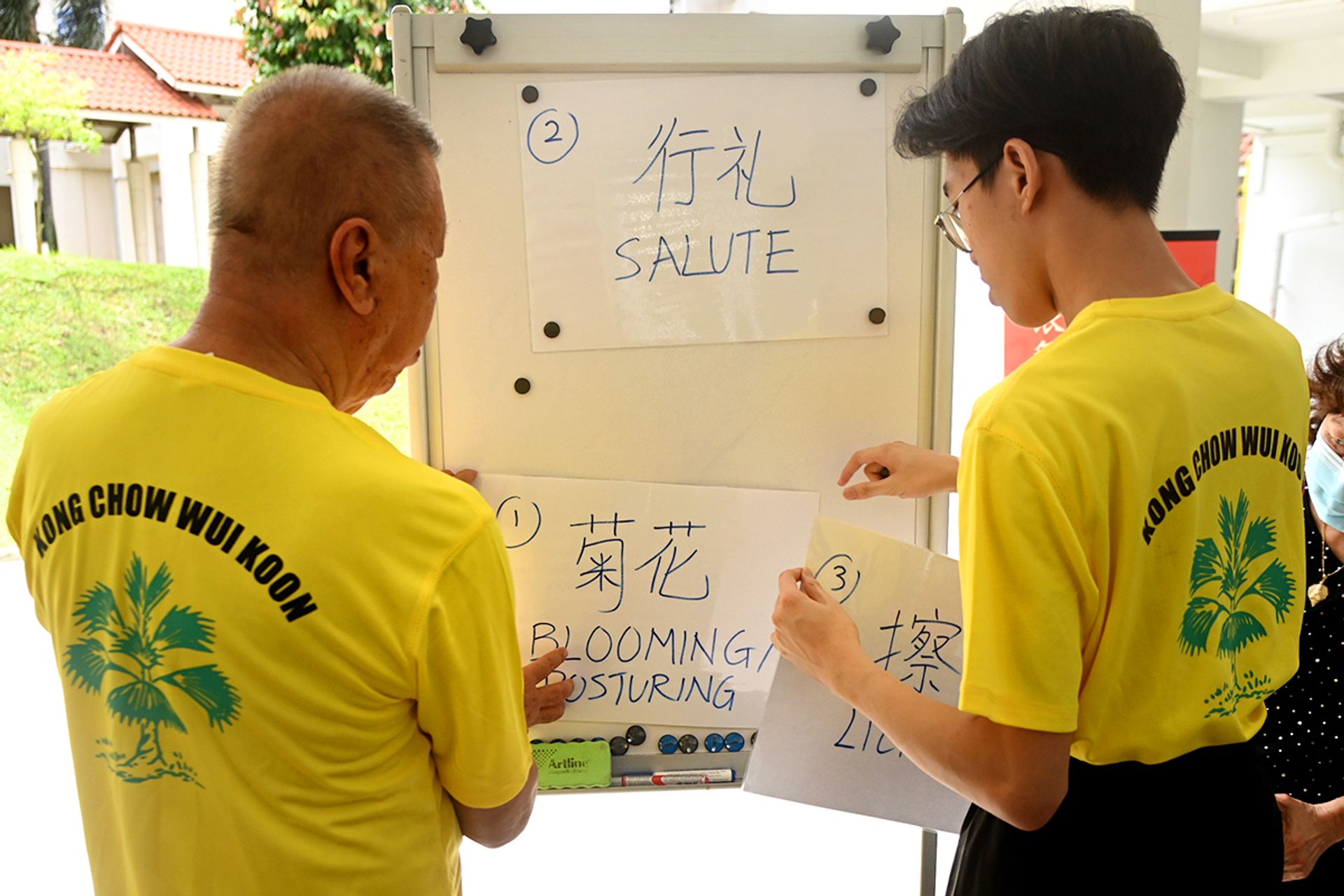 Mr Chua Lai Hock, 74, and Lucas Ow, 16, putting up instructions of lion dance movements outside Fei Yue Active Ageing Centre.