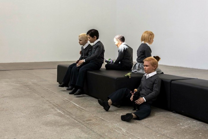 Lifesize model children sit on a bench