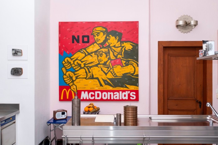 A square painting in primary colours of workers striving above the McDonald’s logo