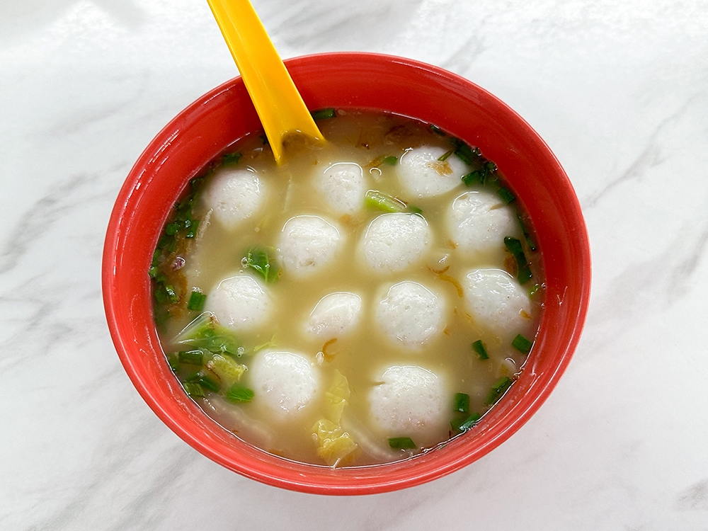 An extra bowl of Fish Balls with clear soup filled with sliced cabbage and tomatoes is the best way to get your fix for the supple handmade fish balls.