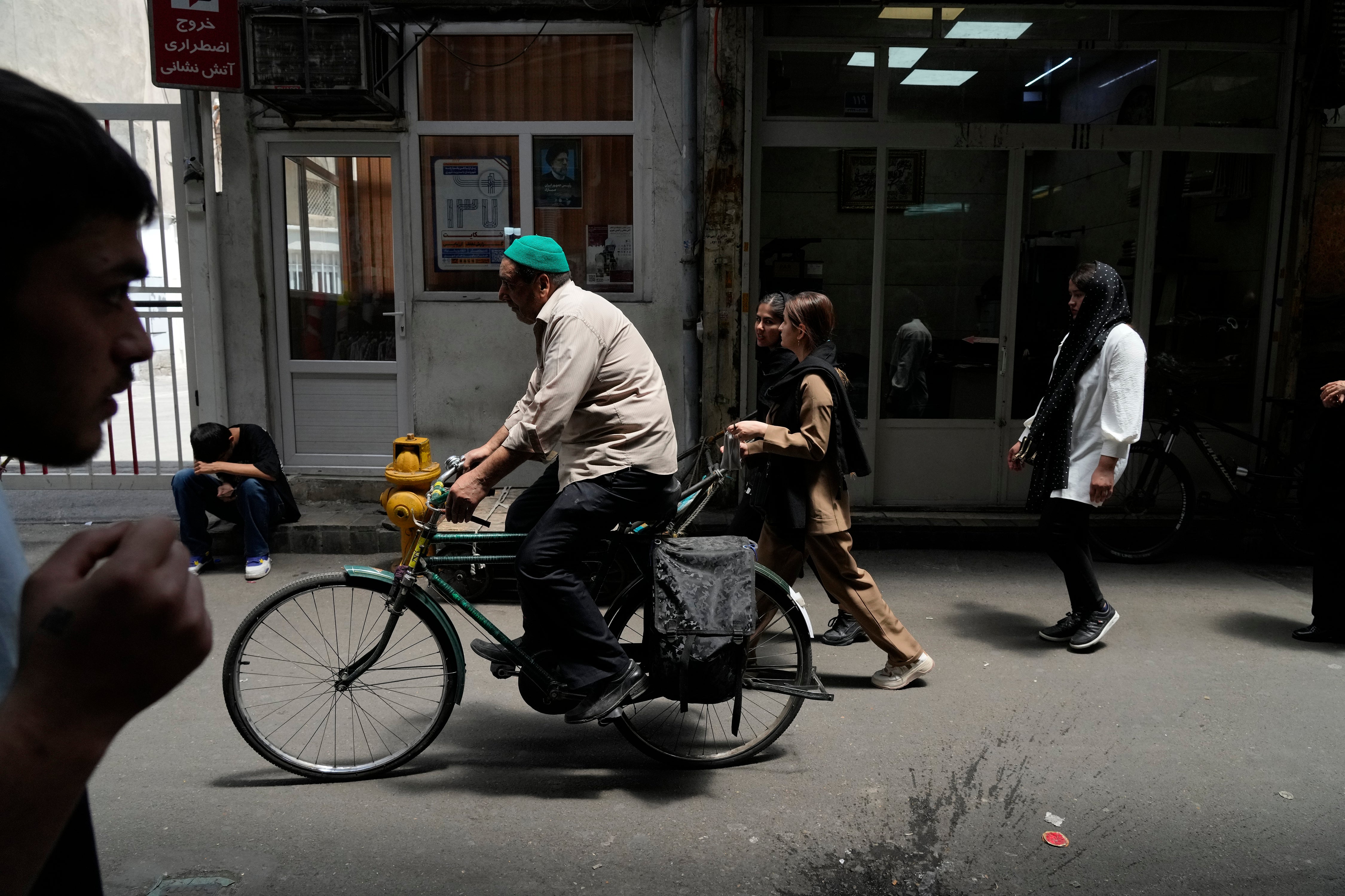 People make their way through the old main bazaar of Tehran, Iran, Thursday, June 13, 2024