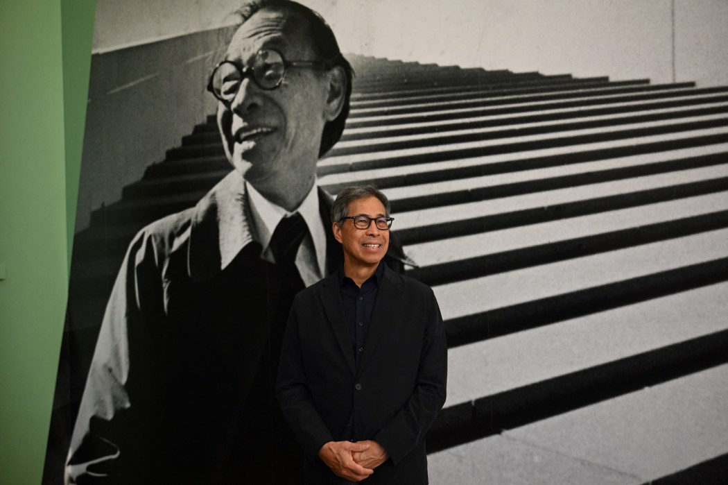 Sandi Pei, son of late Chinese-American architect I.M. Pei, poses in front of a photo of his father at the M+ museum in Hong Kong on June 26, 2024. Photo: Peter Parks/AFP.