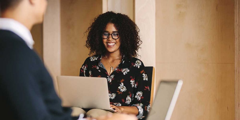 curly-haired-female-takes-notes-as-male-client-dictates