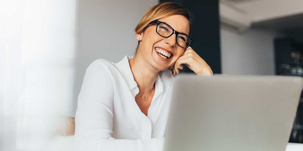 female-designer-smiles-reading-computer