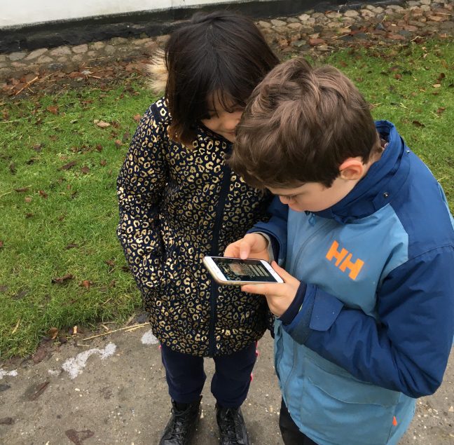 To børn kigger på mobiltelefon