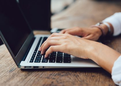 Laptop med kvinna som skriver