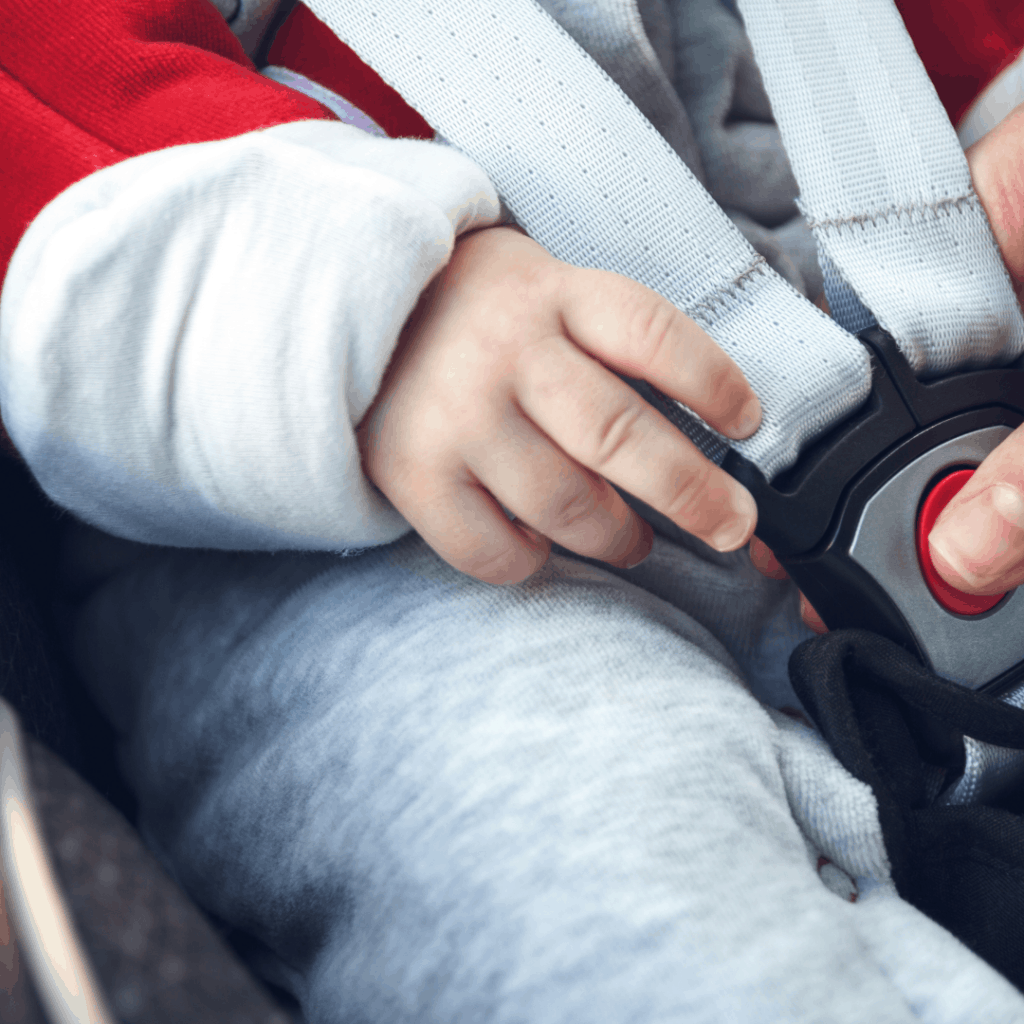 Nærbilde av bilbelte på en baby i babybilstol.