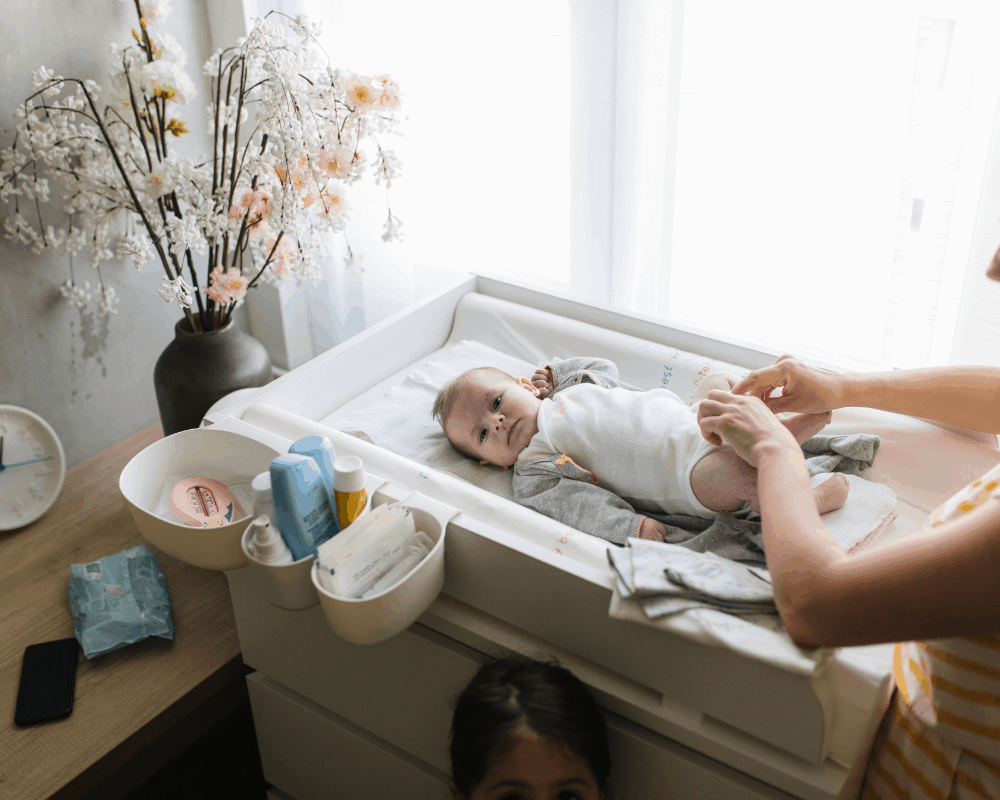 Baby ligger på en stellematte etter bleieskift