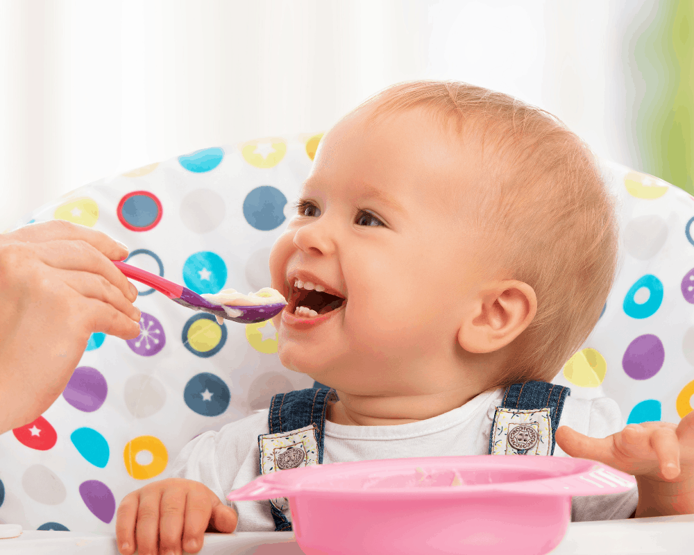 Baby blir matet fra rosa barneservise