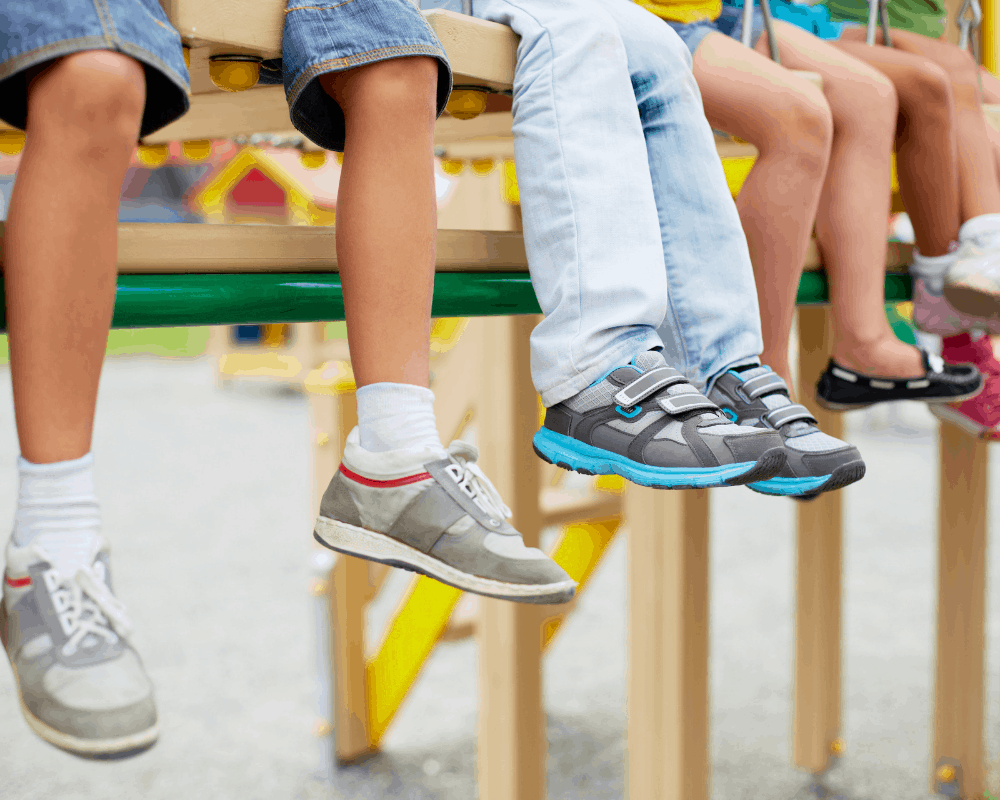 Nærbilde av barns ben og joggesko i forskjellige farger