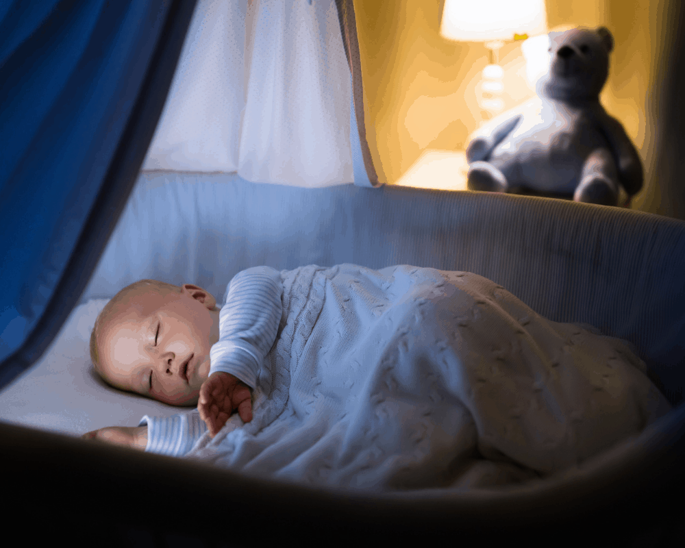 Baby sover på siden i en fin seng uten sidepute