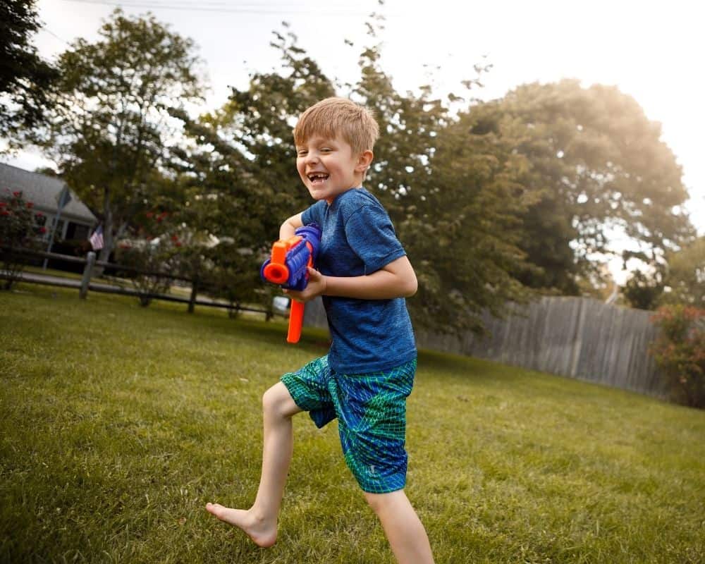 Barn løper og leker med lekevåpen fra NERF