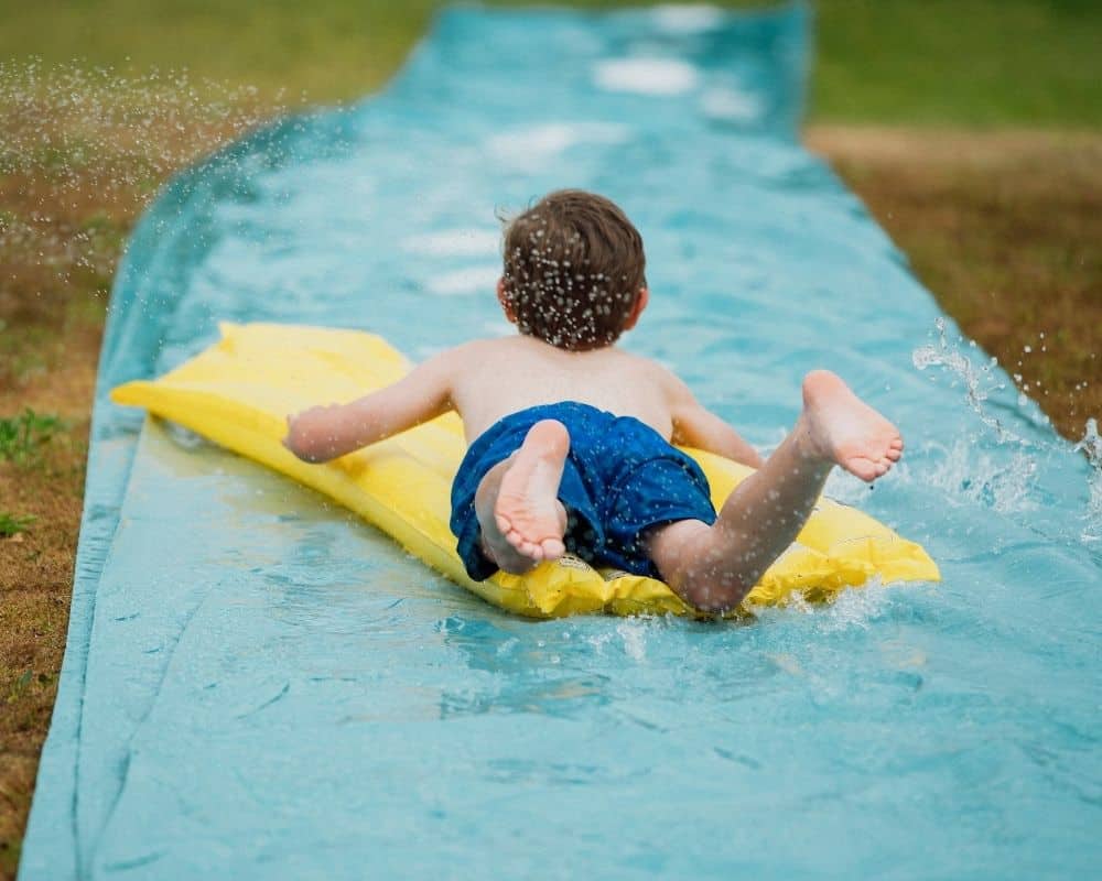Bilde av gutt som glir nedover en vannsklie