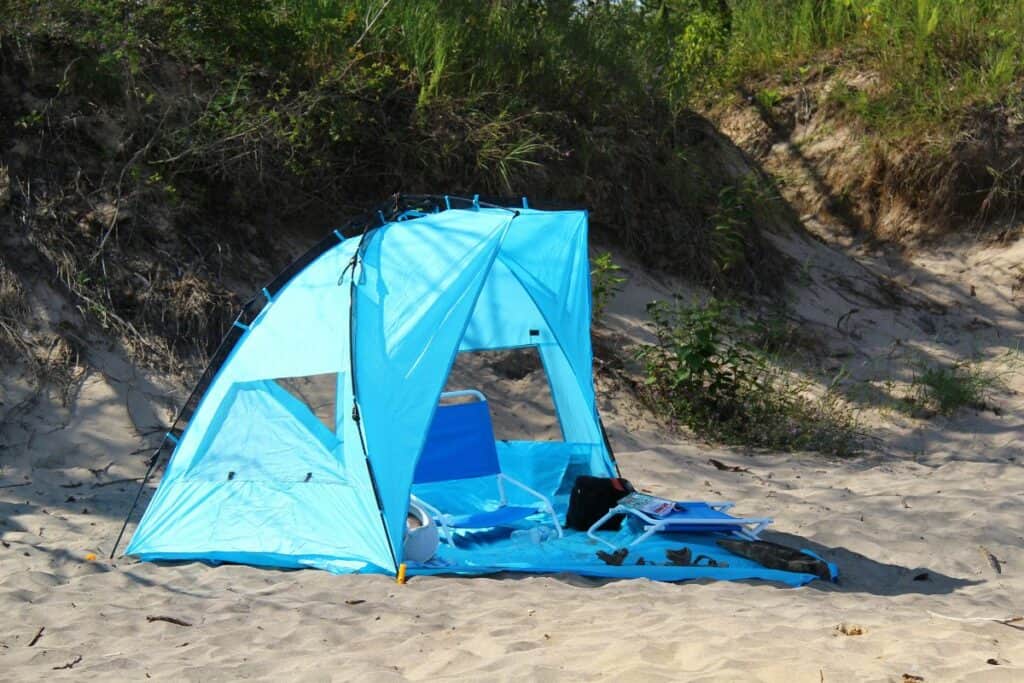 Blått strandtelt satt opp på en sandstrand