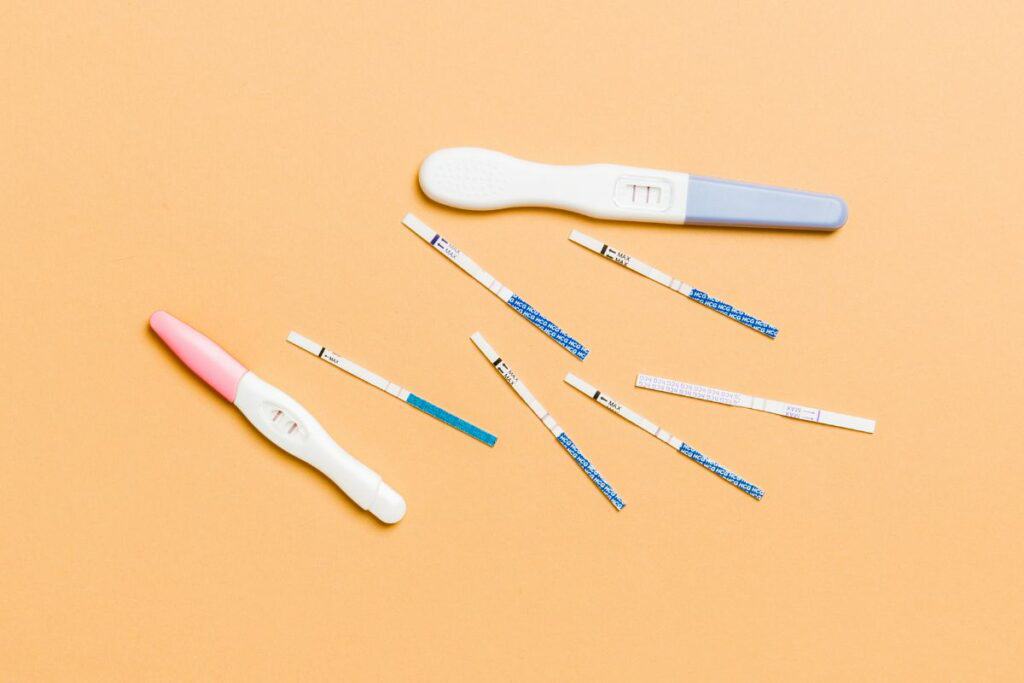 Flere typer graviditetstester på oransje bakgrunn