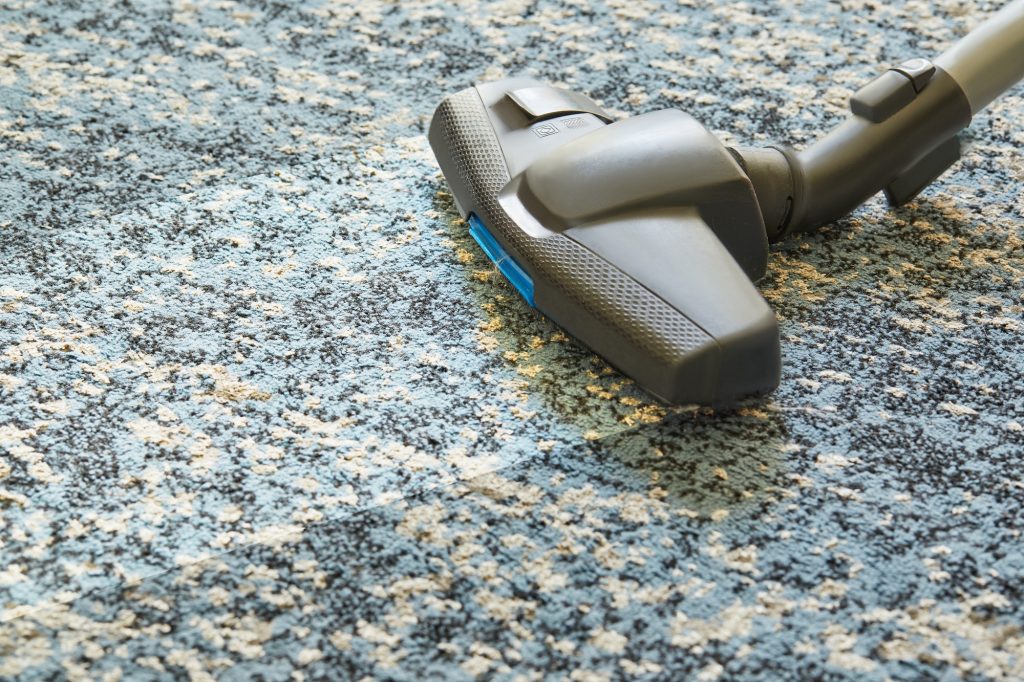 Removing dirt from the carpet with a vacuum cleaner indoors