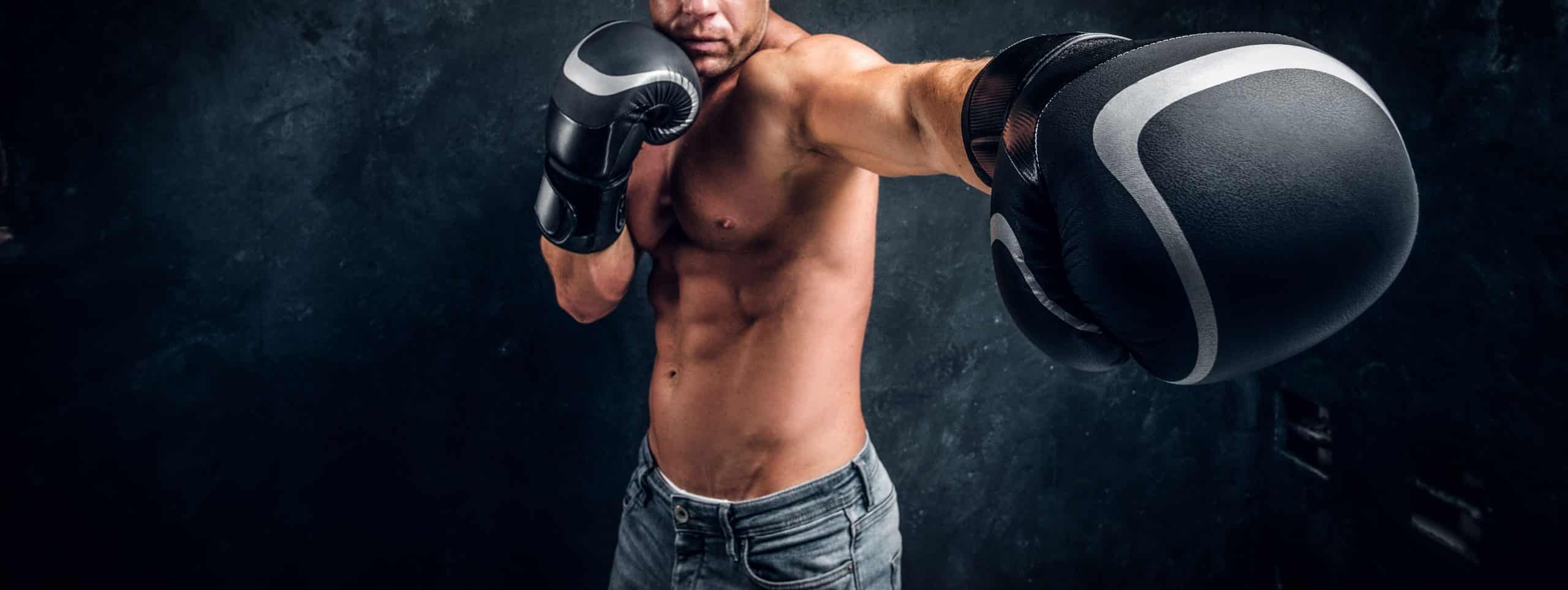 Muscular boxer is warming up before sparring