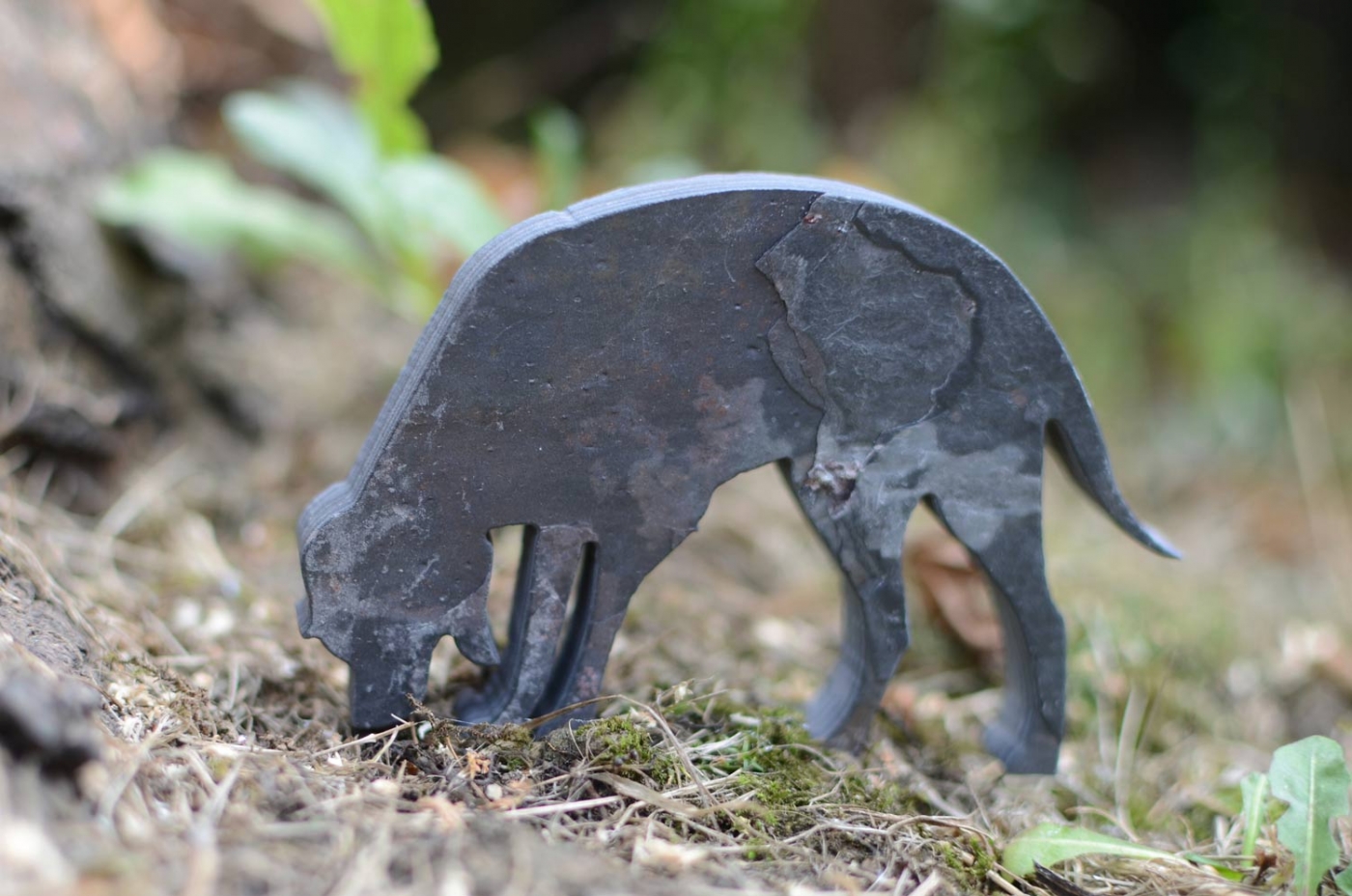 A small slate dog, palm sized.