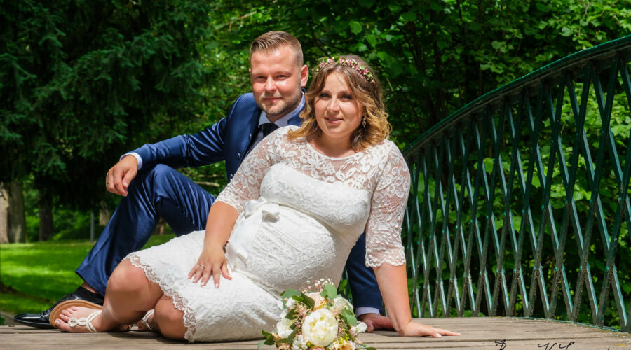 Hochzeitsfotografenmit Brautpaar auf Brücke
