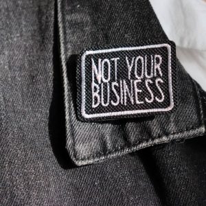 broche "not your business"