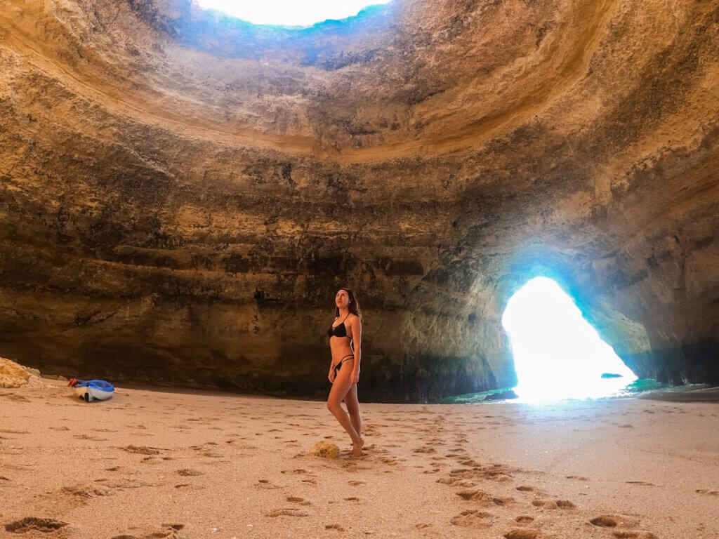 A girls standing inside the Benagil Cave