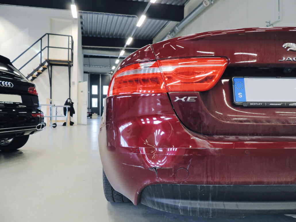Buckla vid höger lyse på röd jaguar