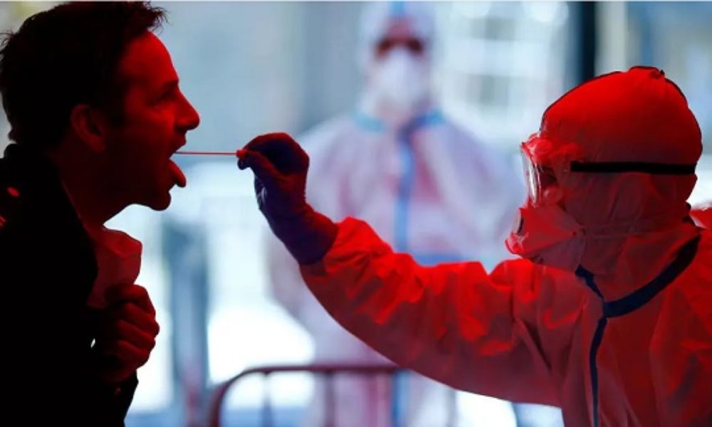 Medical staff in protective gear look at a screen while checking temperatures of passengers upon their arrival, following an outbreak of the coronavirus, at Najaf airport, in the holy city of Najaf