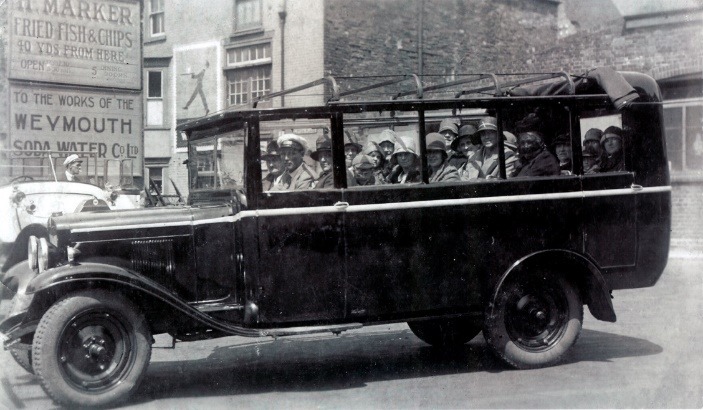 A black and white photo of a car with people in it Description automatically generated with medium confidence