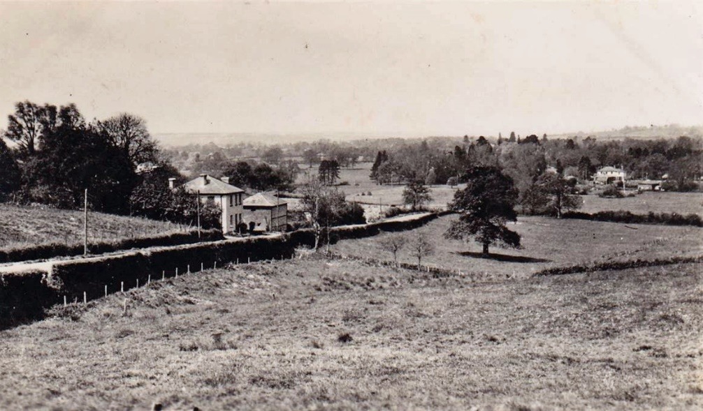 A black and white photo of a farm with a river running through it Description automatically generated with low confidence