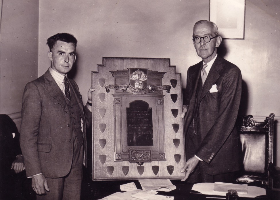 A couple of men standing next to a painting Description automatically generated with low confidence