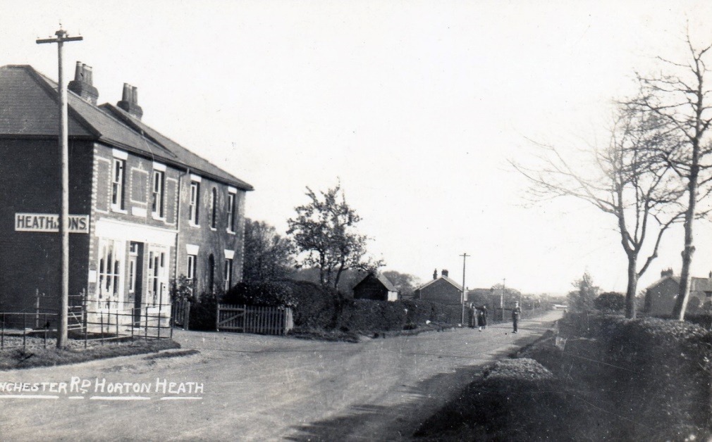 A dirt road with buildings on either side of it Description automatically generated with low confidence