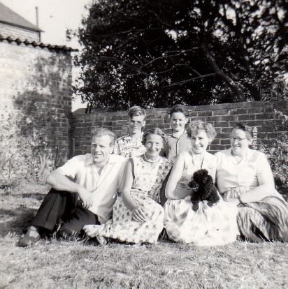 A group of people sitting on the grass Description automatically generated with low confidence