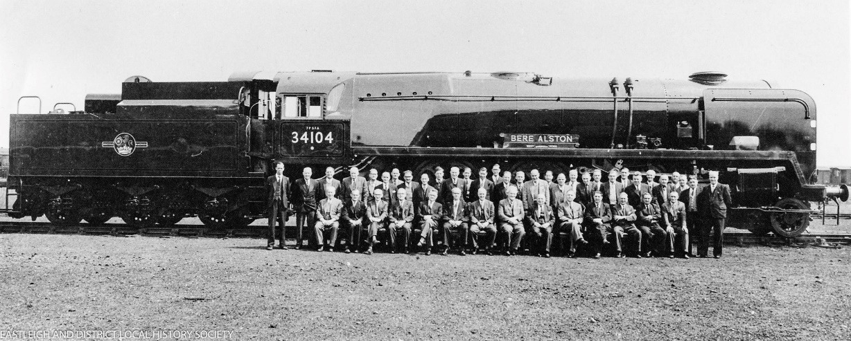 A group of people standing in front of a train Description automatically generated with low confidence