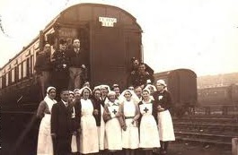 A group of people standing next to a train Description automatically generated with medium confidence