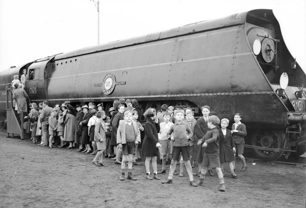 A group of people standing next to a train Description automatically generated with medium confidence
