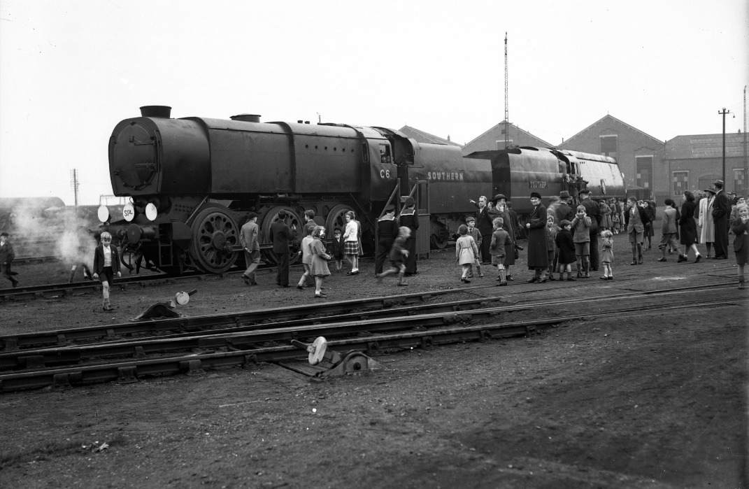 A group of people standing next to a train Description automatically generated with medium confidence