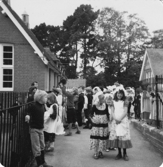 A group of people standing outside a house Description automatically generated with low confidence