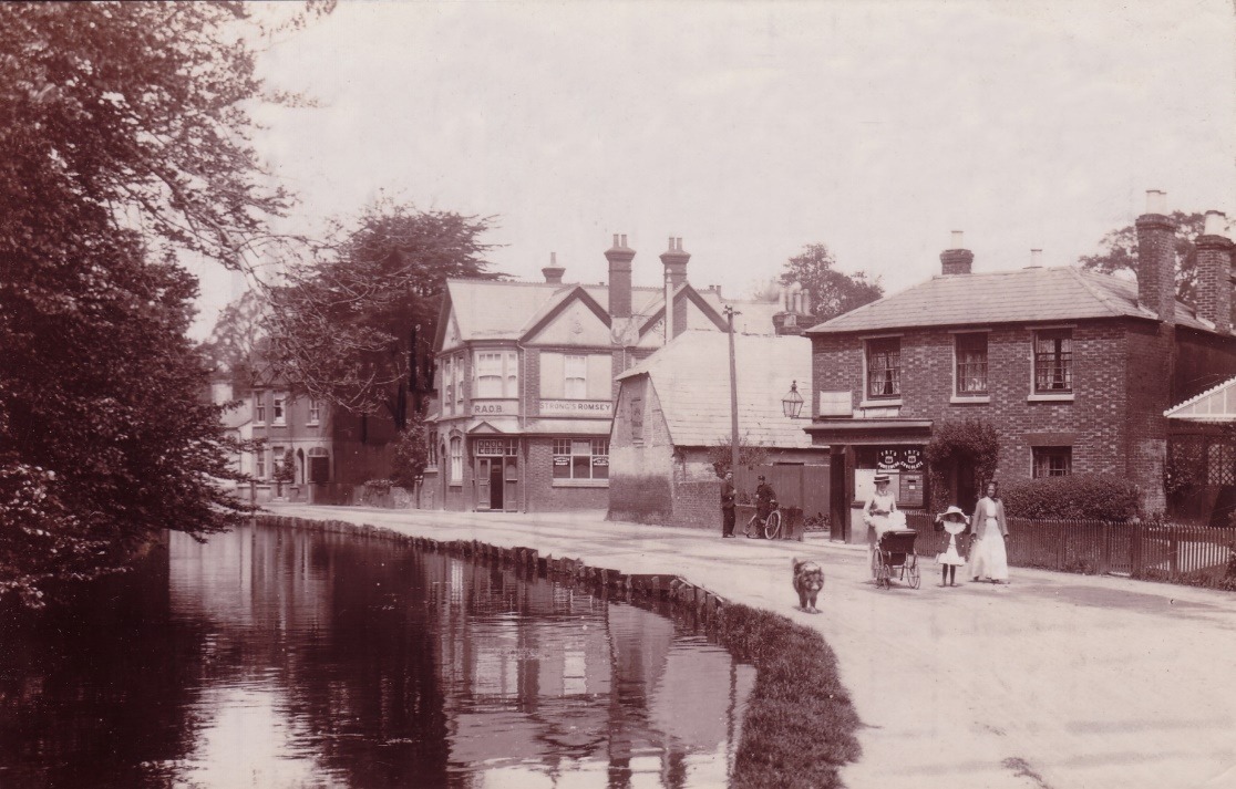 A group of people walking along a road next to a body of water Description automatically generated with low confidence