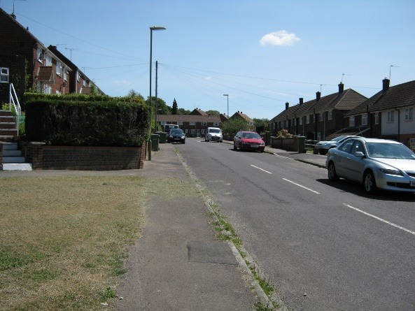 A road with cars on it and houses along it Description automatically generated with low confidence