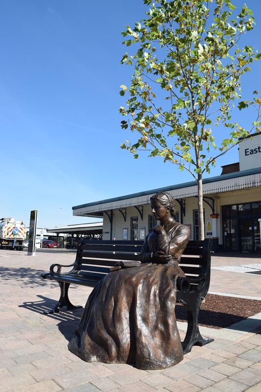A statue of a person sitting on a bench Description automatically generated with medium confidence
