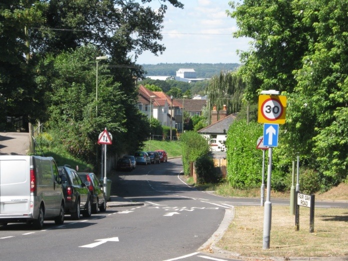 A street sign is posted on the side of a road Description automatically generated with low confidence