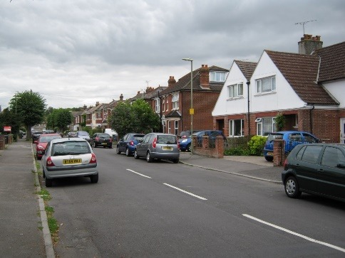 A street with cars parked along it Description automatically generated with medium confidence