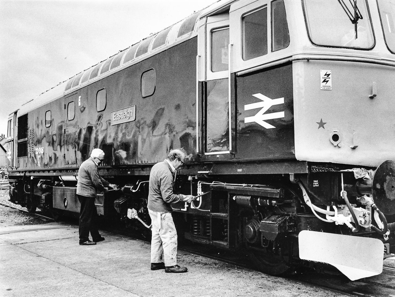 Men standing next to a train Description automatically generated with medium confidence