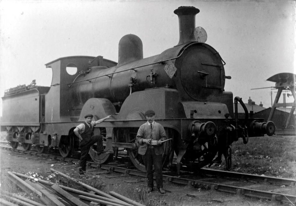 Men standing next to a train Description automatically generated with medium confidence