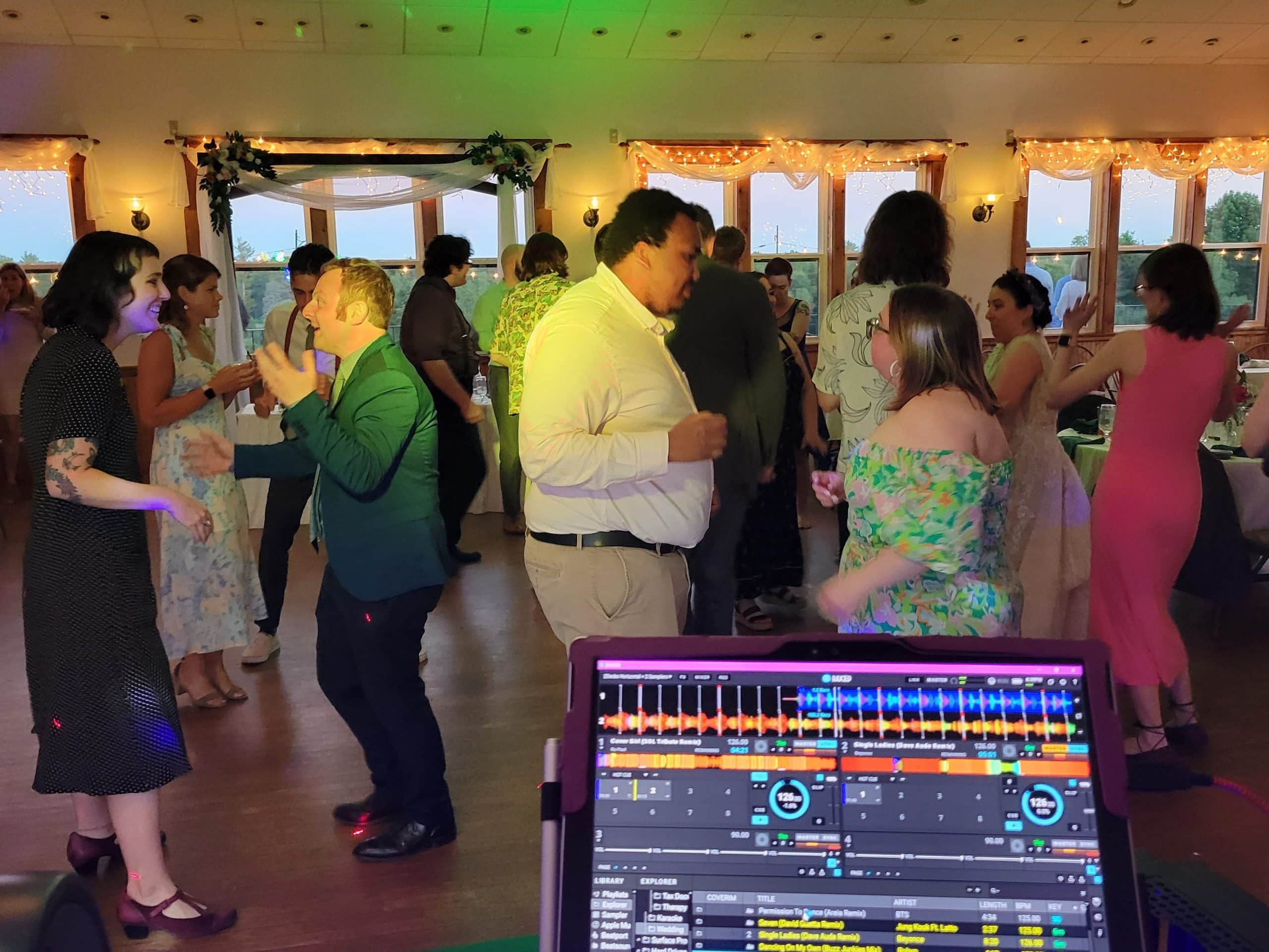 Karaoke Hire for a wedding in South Berwick in York County. Wedding attendees dance together while we see the DJ stand playing music making them happy.