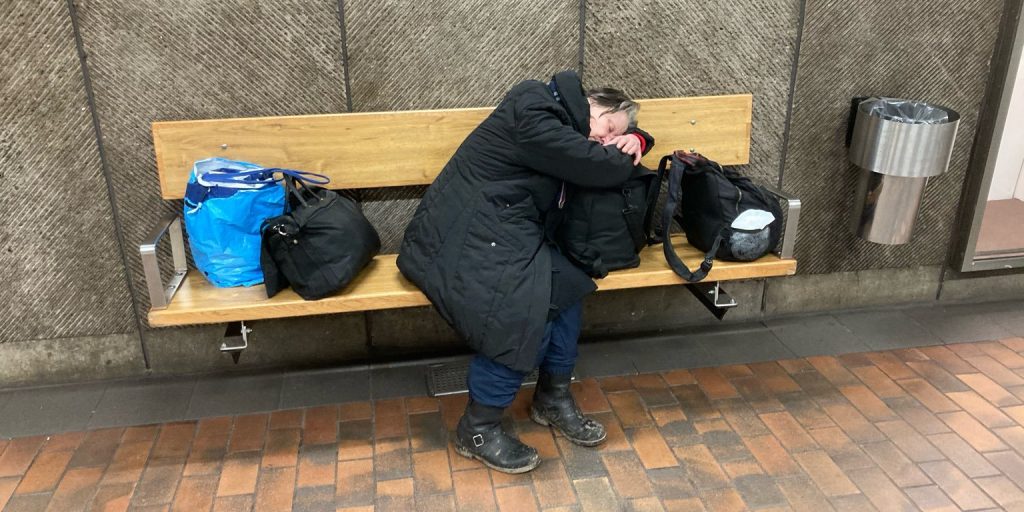 Hemlös kvinna vilar på tunnelbanestation