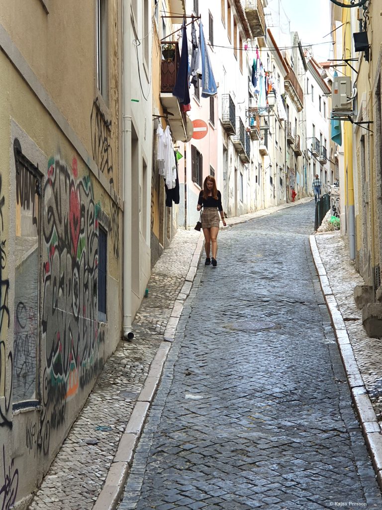 Smal vinglig gata i Lissabon med tvätt hängades från balkongerna