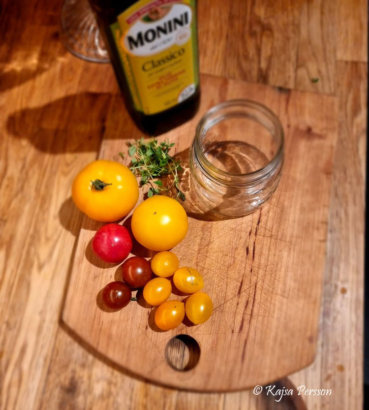 Tomter, timjan, glasbur och olja på en skärbräda är ett av de tomat recept jag testar