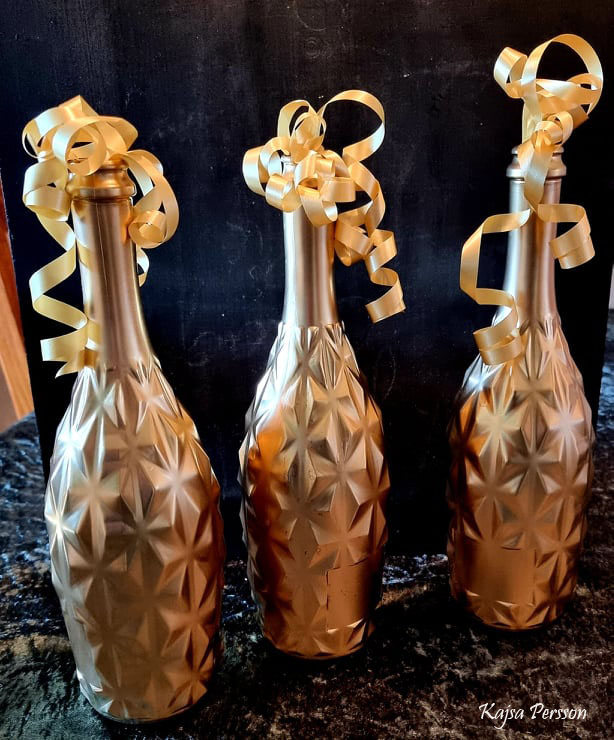 Tre Bubblande guldriga champangeflaskor som dekoration